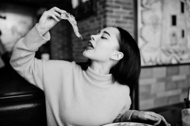 Esmer kız sarı kazaklı pizza restoranında yemek