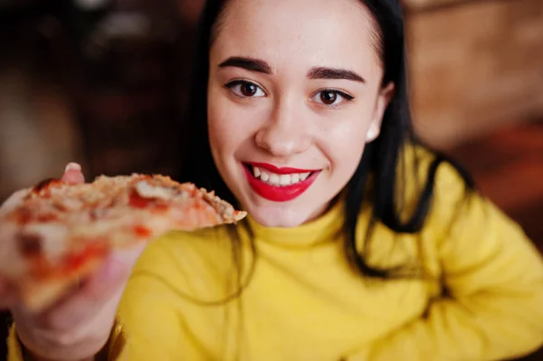 Zabawna Dziewczyna Brunetka w żółty sweterek jedzenie pizza w restauracji — Zdjęcie stockowe