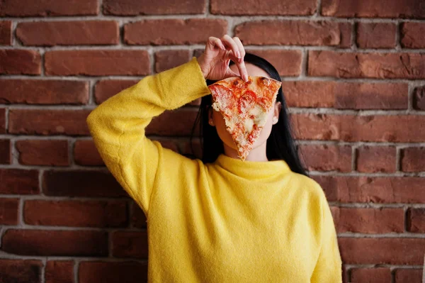 Vicces barna lány pizzát eszik étteremben sárga pulóver — Stock Fotó