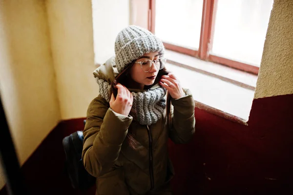 Retrato de chica morena en bufanda gris y sombrero, gafas cerca de wi — Foto de Stock