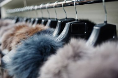Bir tasarımcı kürk giyim mağazası bir raf kıyafet dayan.