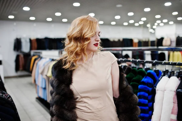 Elegantie blond meisje in bontjas in de winkel van bontjassen en l — Stockfoto