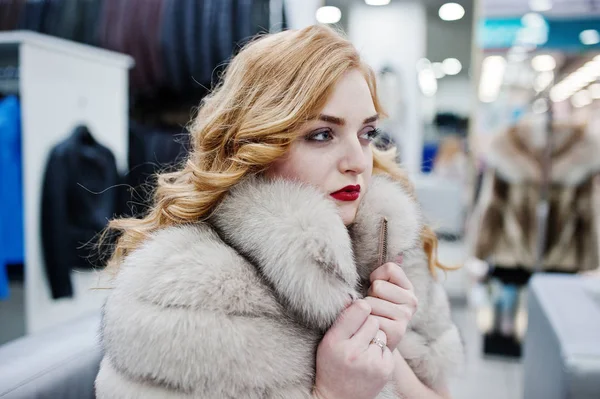 Elegance blonde girl in fur coat at the store of fur coats and l — Stock Photo, Image