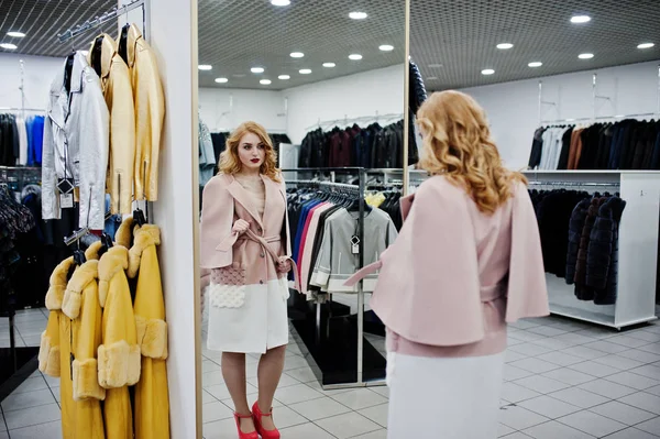 Elegance blonde girl in coat at the store of fur coats and leath — Stock Photo, Image