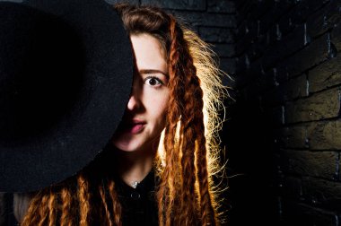 Kız dreads ve tuğla backg şapka ile siyah stüdyo çekimleri
