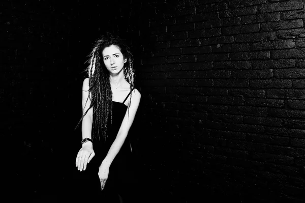Studio shoot de fille en noir sur chaise avec des dreads sur le dos de brique — Photo