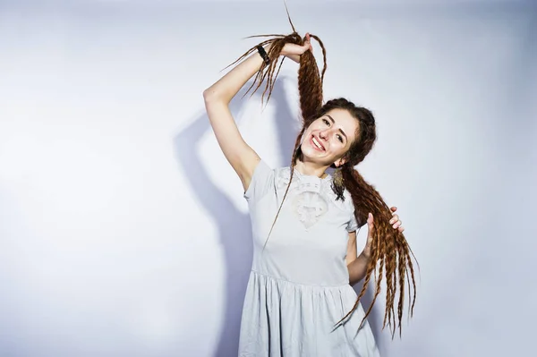 Estudio disparar de chica en vestido gris con rastas coletas en blanco —  Fotos de Stock