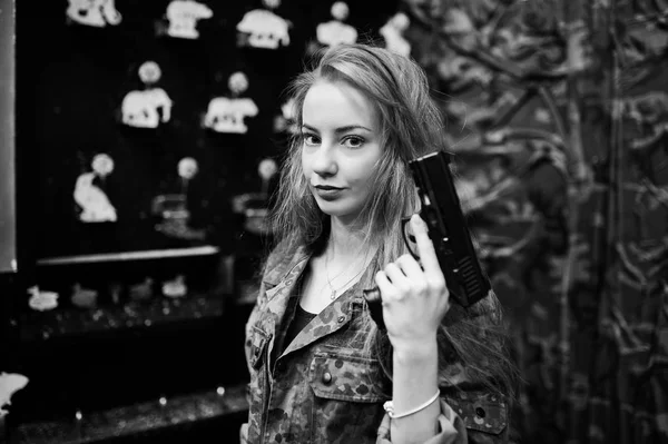 Military girl in camouflage uniform with gun at hand against arm — Stock Photo, Image