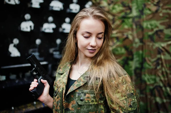 Fille militaire en uniforme de camouflage avec arme à la main contre bras — Photo