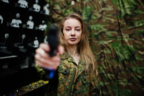 Fille militaire en uniforme de camouflage avec arme à la main contre bras — Photo