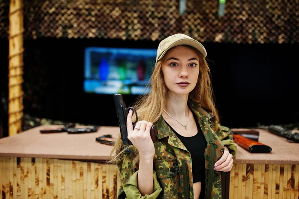Military girl in camouflage uniform with gun at hand against arm — Stock Photo, Image