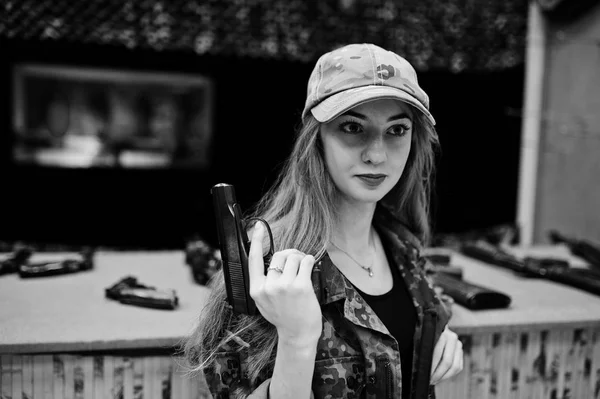 Menina militar em uniforme de camuflagem com arma na mão contra braço — Fotografia de Stock