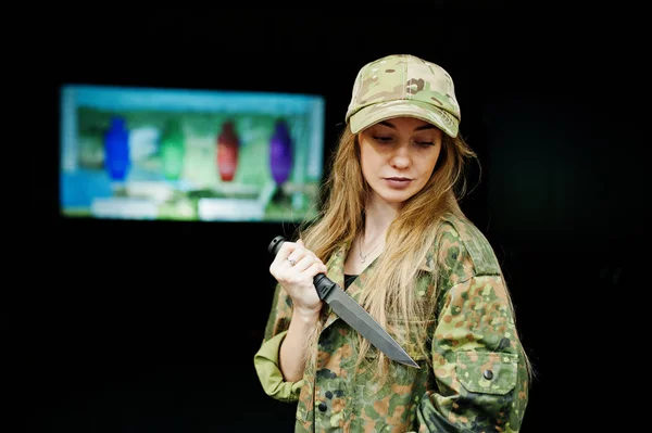 Militaire fille en uniforme de camouflage avec couteau à portée de main contre un — Photo