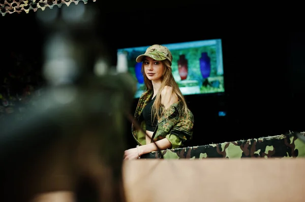 Menina militar em uniforme de camuflagem contra fundo do exército em s — Fotografia de Stock