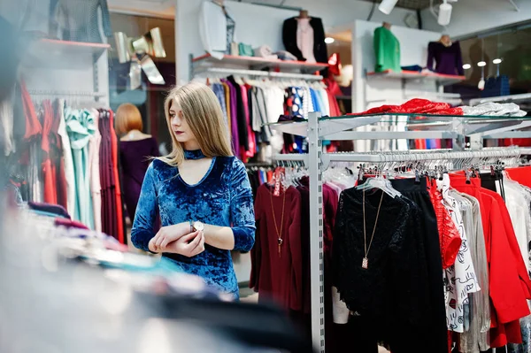 Chica rubia en vestido azul en la tienda de ropa boutique . — Foto de Stock