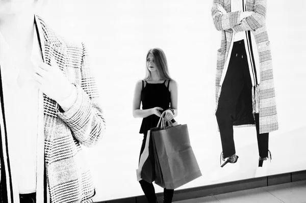 Meisje met boodschappentassen in het winkelcentrum tegen mannequins in de sh — Stockfoto