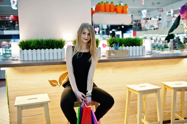 ショッピング モールの座っている椅子にバッグを持つ少女. — ストック写真