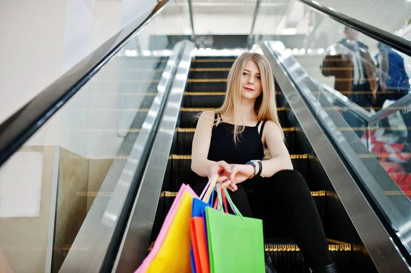 Chica con bolsas de compras en el centro comercial en la escalera mecánica . —  Fotos de Stock
