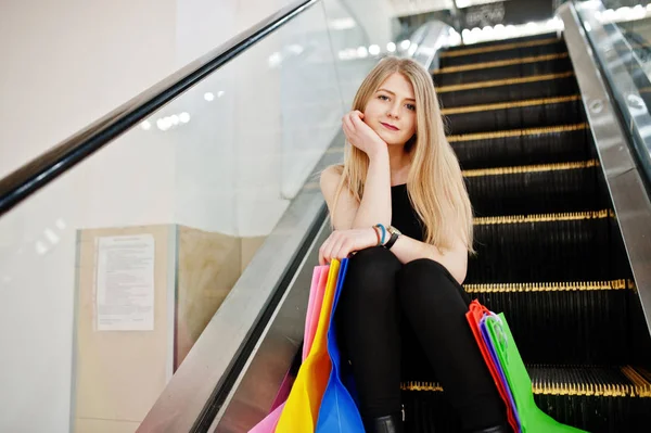 Chica con bolsas de compras en el centro comercial en la escalera mecánica . —  Fotos de Stock