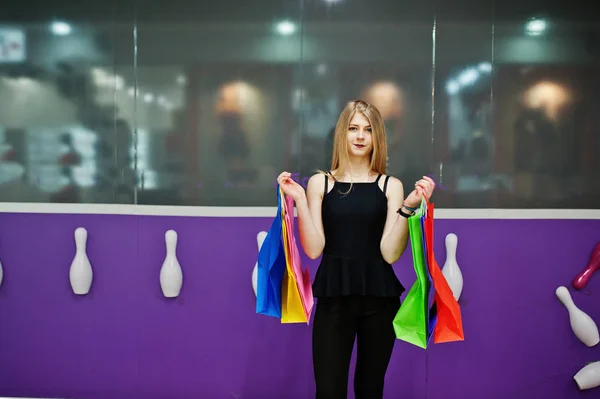 Mädchen mit Einkaufstüten im Einkaufszentrum gegen Kegelclub-Wand. — Stockfoto