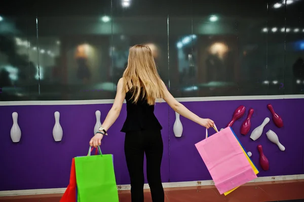 Meisje met boodschappentassen in het winkelcentrum tegen club muur Bowlen. — Stockfoto