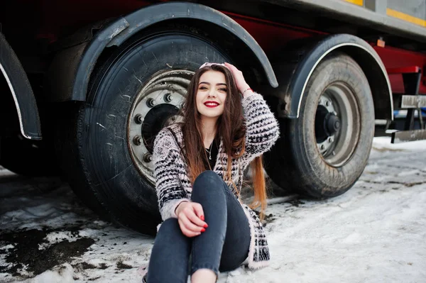 Brunette élégant casual fille en chapeau assis contre roues de camion — Photo