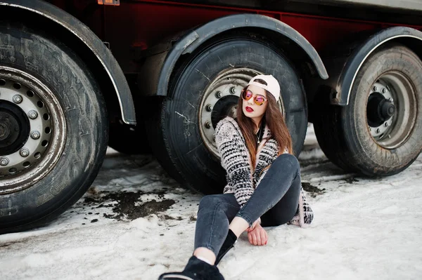 Brunette élégant casual fille en casquette et lunettes de soleil assis à nouveau — Photo