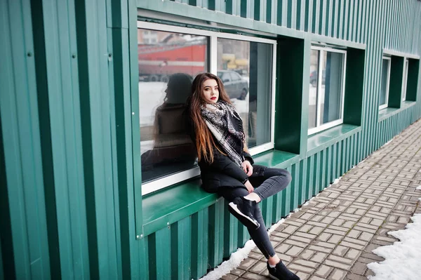 Брюнетка стильная случайная девушка в шарфе против зеленого металлического валя — стоковое фото