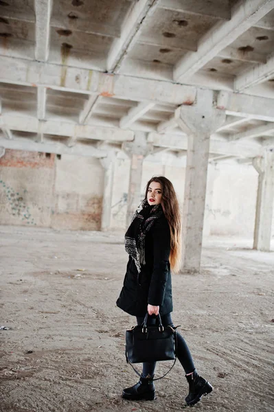 Brunette stylish casual girl in scarf and handbag against abando — Stock Photo, Image