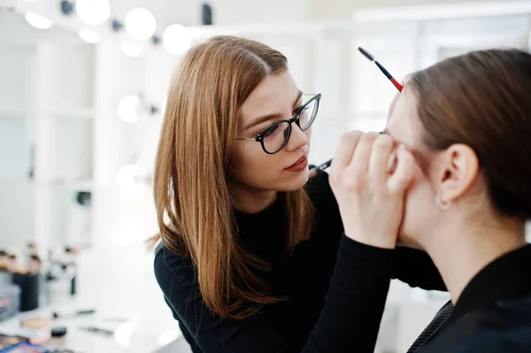 Make up artist work in her beauty visage studio salon. Woman app