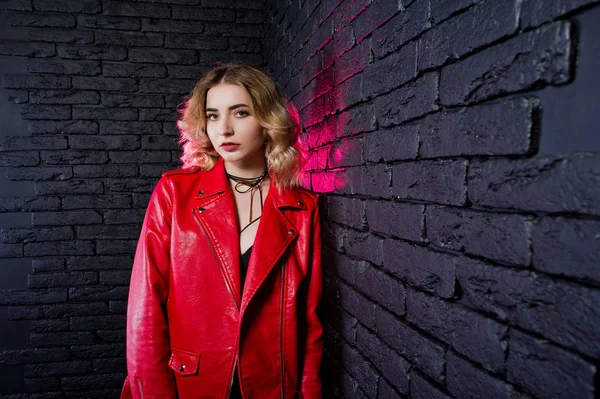 Estudio retrato de chica rubia en chaqueta de cuero rojo contra bri — Foto de Stock