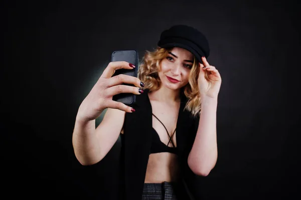 Студійний портрет блондинки в чорному одязі, бюстгальтер і кепка — стокове фото