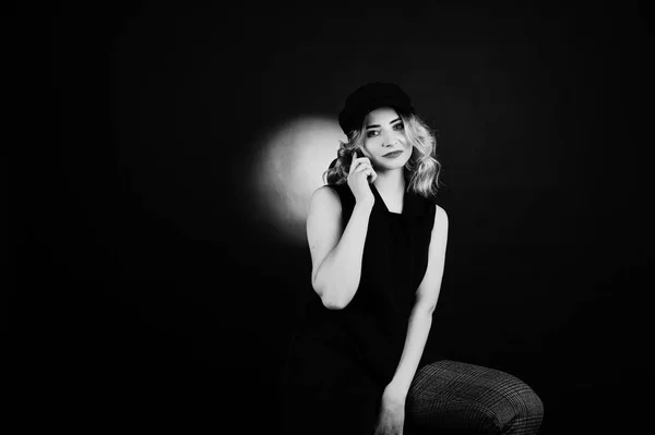 Studio portrait of blonde girl in black wear and cap with mobile — Stock Photo, Image