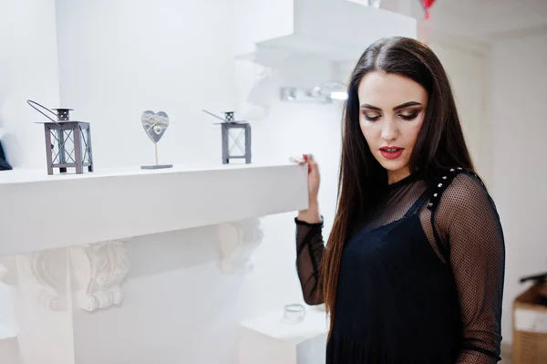Брюнетка шикарная девушка в бутике магазина одежды в черном — стоковое фото