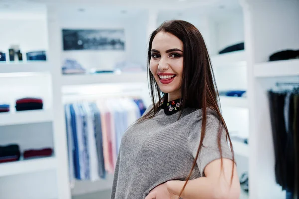 Brünette wunderschöne Mädchen in der Bekleidungsgeschäft Boutique bei grau dr — Stockfoto