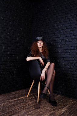 Siyah deri elbiseli esmer kıvırcık saçlı uzun bacaklı kız ve 