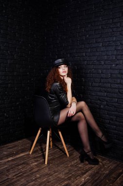 Siyah deri elbiseli esmer kıvırcık saçlı uzun bacaklı kız ve 