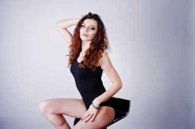 Esmer kıvırcık saçlı uzun bacaklı kız siyah mayo üzerinde poz verdi 