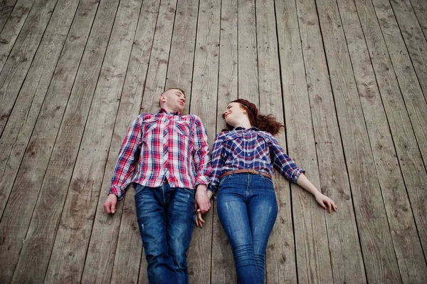 Stylish couple wear on checkered shirt in love together lie on t — Stock Photo, Image