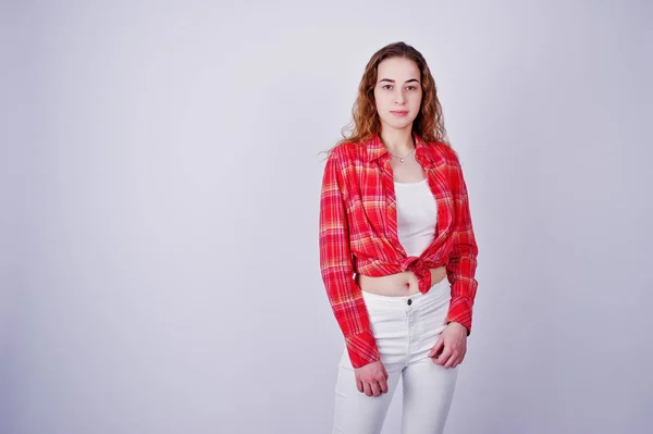 Menina jovem em vermelho verificado camisa e calças brancas contra ba branco — Fotografia de Stock