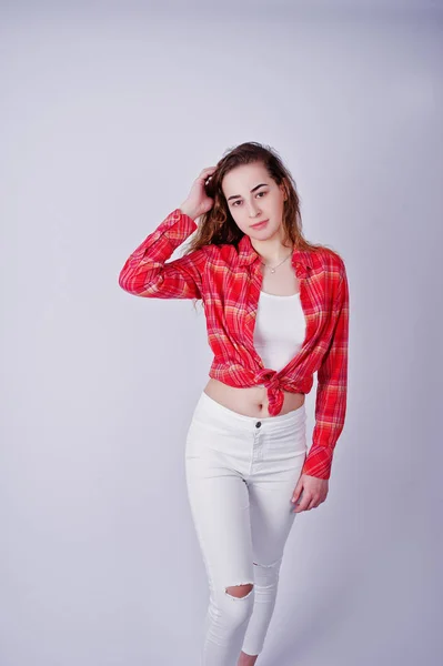 Giovane ragazza in camicia rossa a quadri e pantaloni bianchi contro ba bianco — Foto Stock