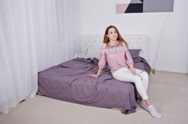 Genç kız yatakta Stüdyo Oda poz verdi..