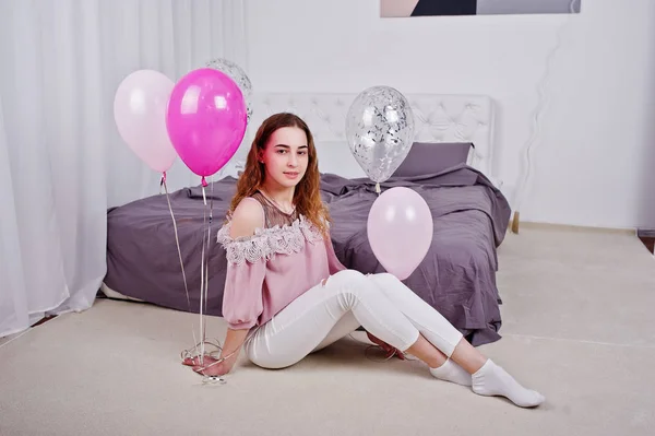 Νεαρό κορίτσι με μπαλόνια σε κρεβάτι που θέτεται στο δωμάτιο στούντιο. — Φωτογραφία Αρχείου