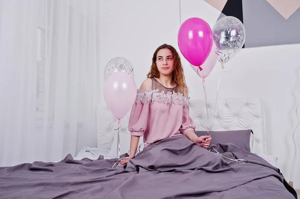 Młoda dziewczyna z balonów na łóżku na Pokój typu studio. — Zdjęcie stockowe