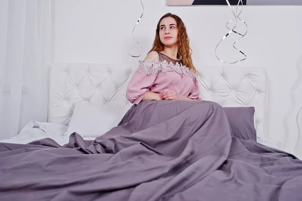 Chica joven en la cama posó en la habitación del estudio . — Foto de Stock