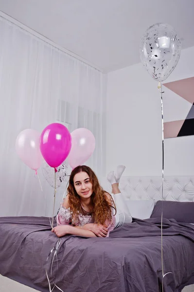 Jeune fille avec des ballons sur le lit posé sur la salle de studio . — Photo