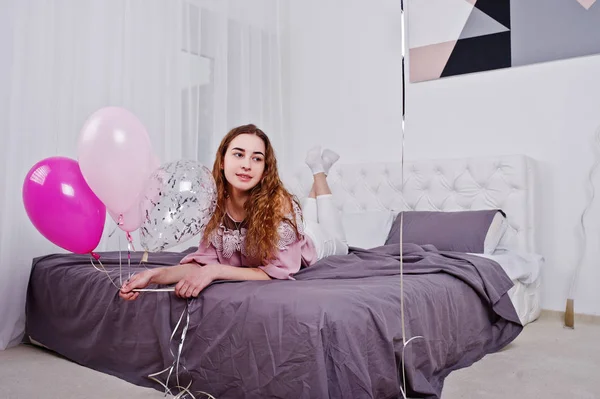 スタジオ ルームのベッドの上の風船を持つ少女がもたらされる. — ストック写真