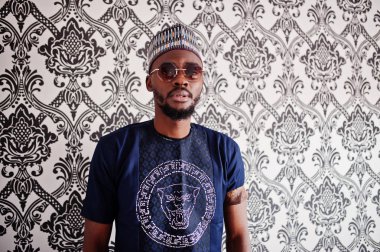 Zengin Afrika adam şık geleneksel giysiler ve şapka cam