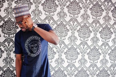 Zengin Afrika adam şık geleneksel giysiler ve şapka cam