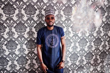 Zengin Afrika adam şık geleneksel giysiler ve şapka cam